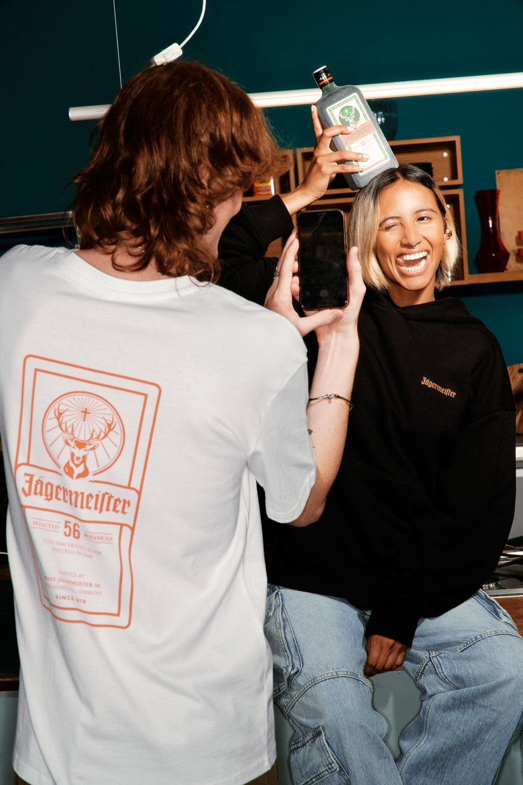 Two people with Jägermeister branding in a casual setting.