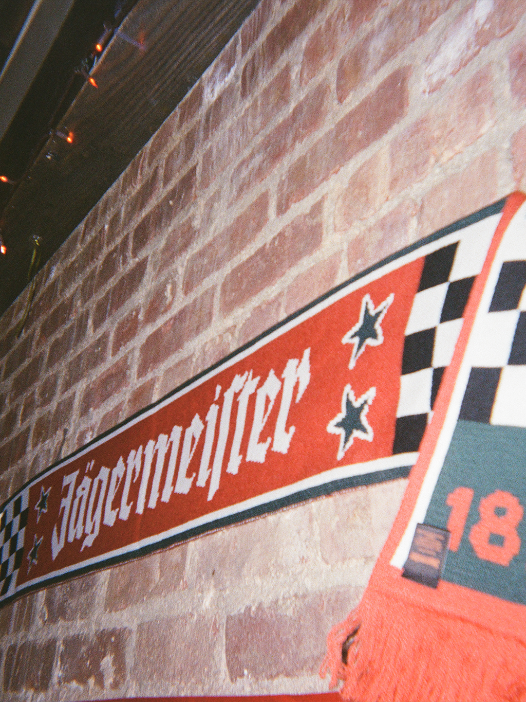 Jägermeister Racing scarf against a brick wall.
