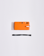 Orange camera with a strap on a white background