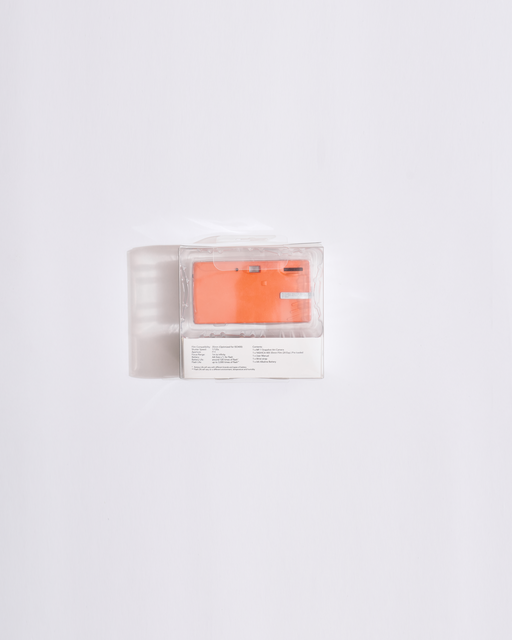 orange camera  in a clear plastic packaging on a white background