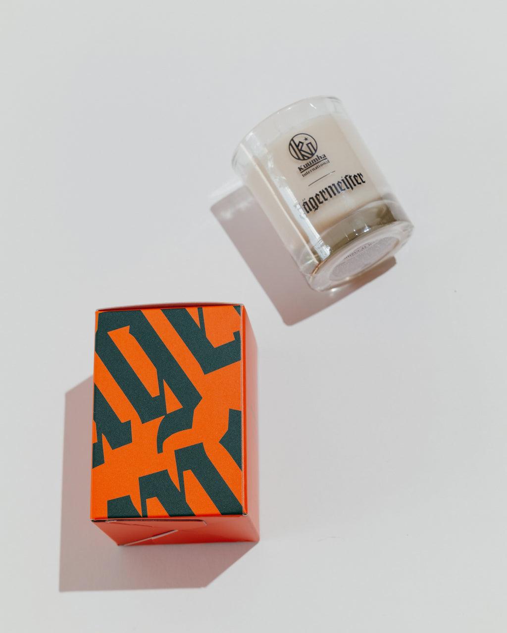 Vela Jägermeister com caixa decorativa com a wordmark Jägermeister em verde e laranja