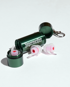 Protetores auriculares numa caixa metálica verde com a marca Jägermeister em branco, sobre fundo branco