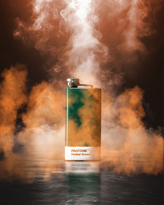 Pantone flask with green color swatch surrounded by colorful smoke on a dark background