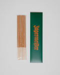 Pauzinhos de incenso com uma caixa verde com branding Jägermeister sobre um fundo branco