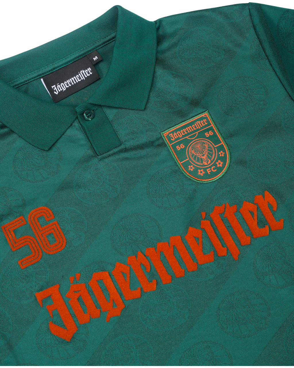 Plano aproximado de uma camisola verde com branding Jägermeister.
