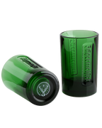 Two green Jägermeister glasses, one standing upright and one lying on its side, with embossed branding and the stag logo visible.