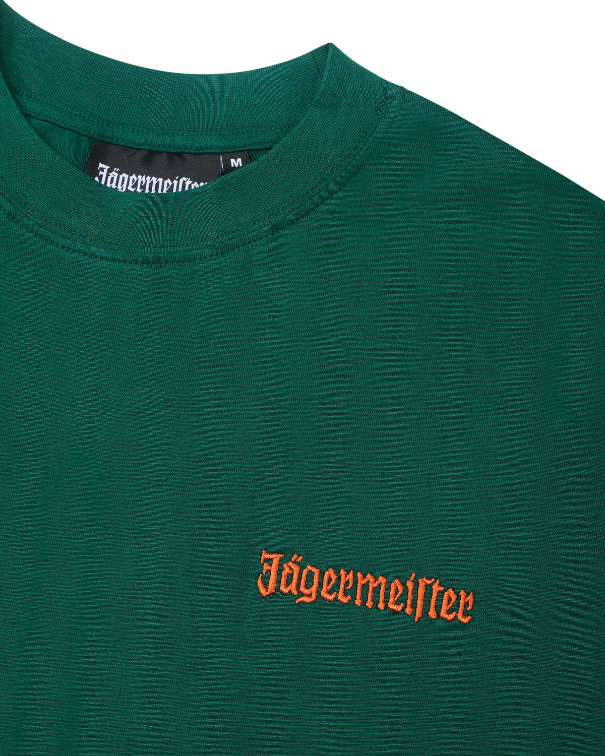 T-shirt verde com o texto Jägermeister laranja no peito.