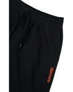Black track pants with orange Jägermeister logo on the side.