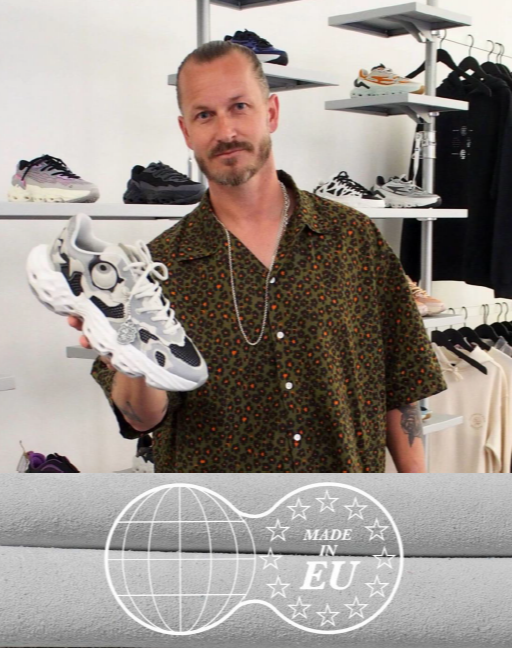 A man in a patterned shirt holds up a chunky white and gray sneaker with rhinestone details. The background shows shelves of other sneakers in a retail store setting, with a 'Made in EU' graphic overlay at the bottom.